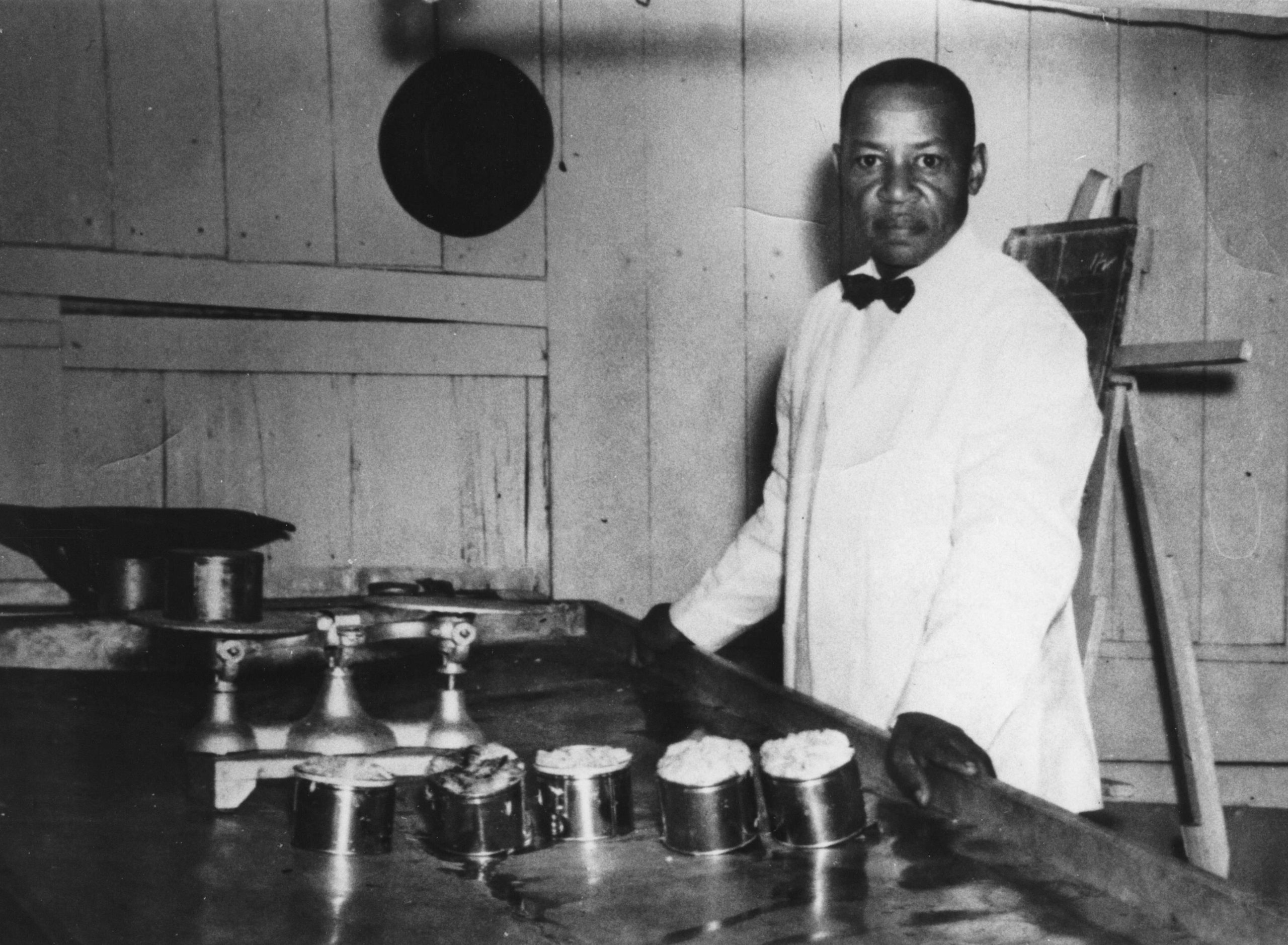 Elwood Jewett of Coulbourne and Jewett is pictured with tins of picked crabmeat. Photo courtesy of Blanche Jewett. Collection of the Chesapeake Bay Maritime Museum, 336.0008.