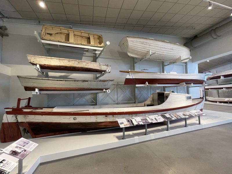 Work boats like Alverta, Pilot’s Gig, & Glide on display in Water Lines. Photograph by A.J. Daverede.